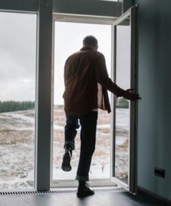 Man som går ut genom en dörr mot fjället